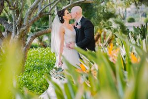 bride and groom kiss with flowers in foreground by Wanderlight, A Phoenix wedding photography company