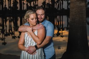 Phoenix wedding photograph of engaged couple hugging with palm trees