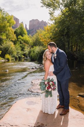 Phoenix wedding photograph of groom kissing bride on river